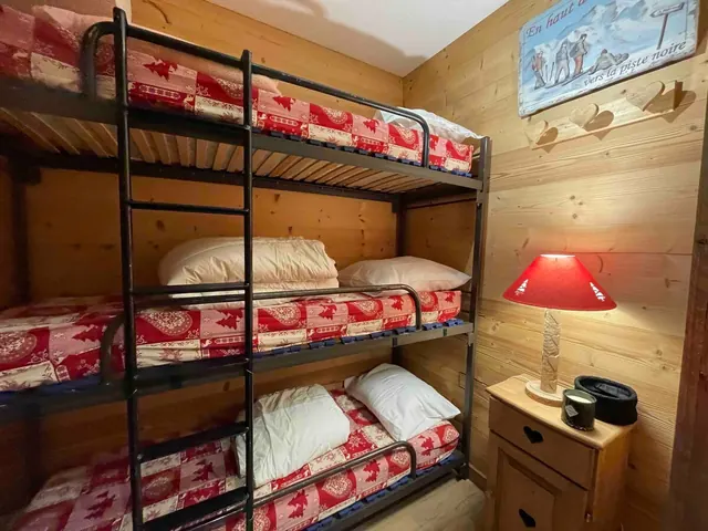 La cabine et ses lits superposés à trois couchettes.
